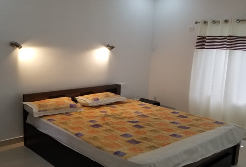 Air-conditioned bedroom with a wide double bed and warm wall lamps