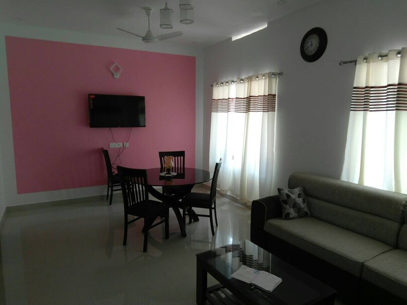 Spacious living area with sofa, television and dining table