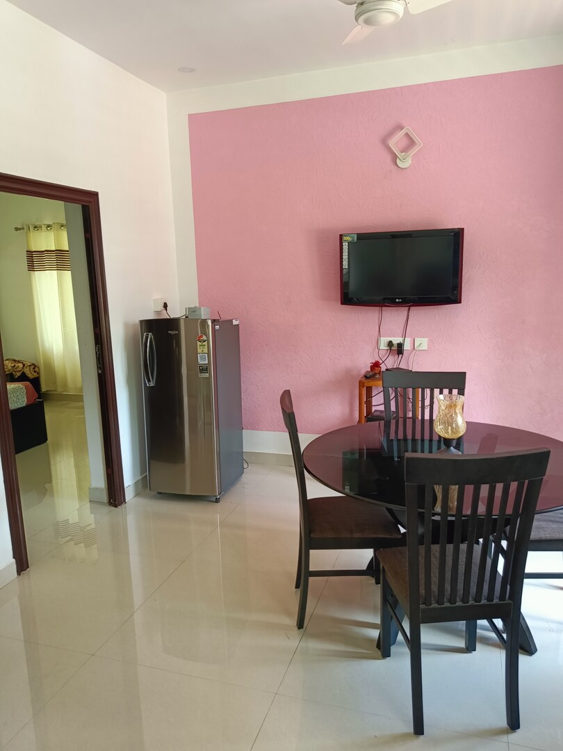Dining table for four beside the refrigerator and television